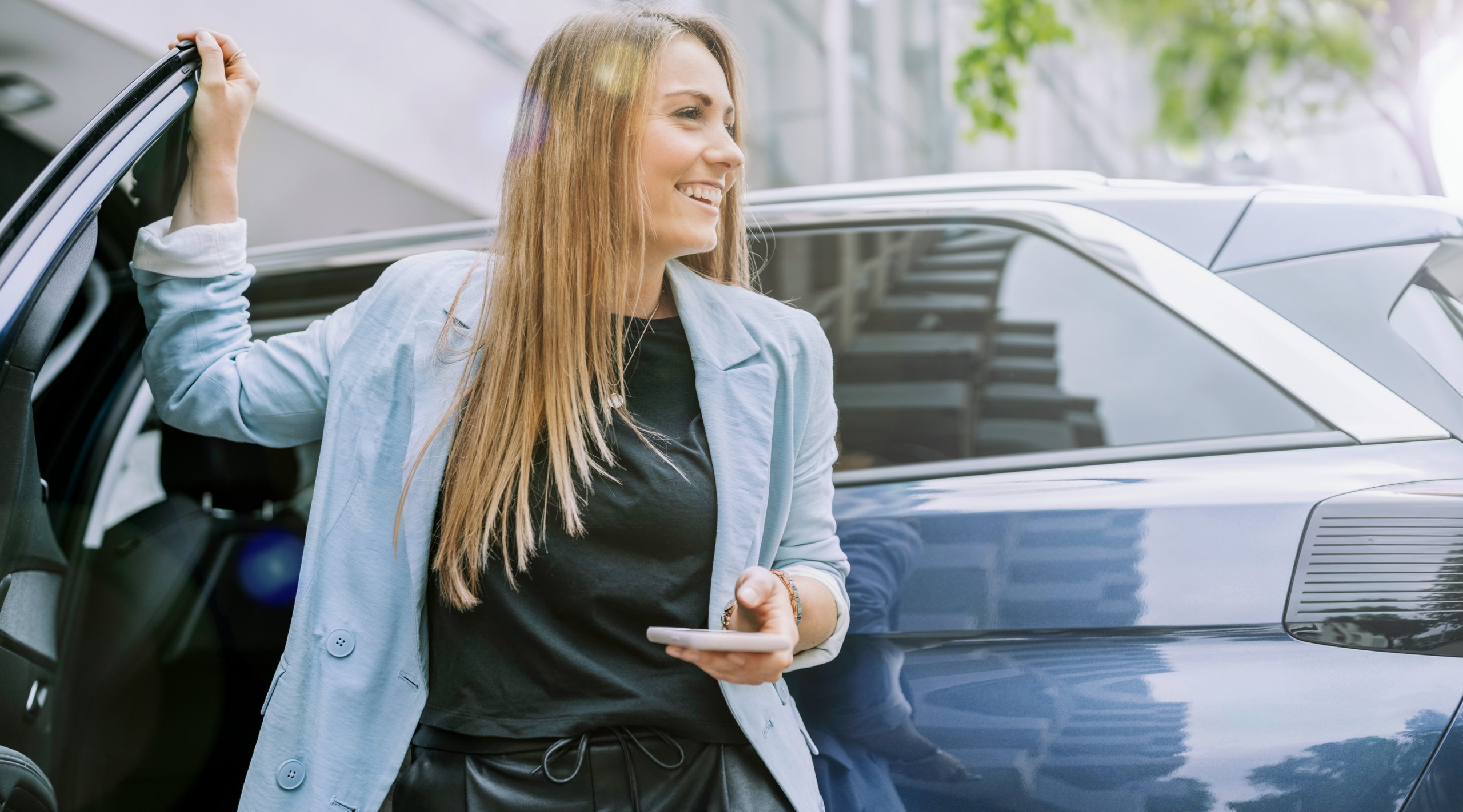 Glad kvinde i bymiljĂž bruger APCOA PARKING til nem og fleksibel parkering